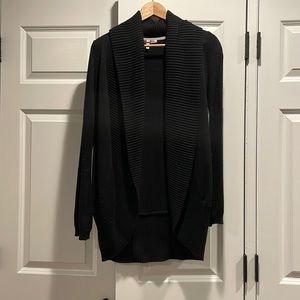 Black cardigan, made of cotton. Bits at the hips. Very warm.